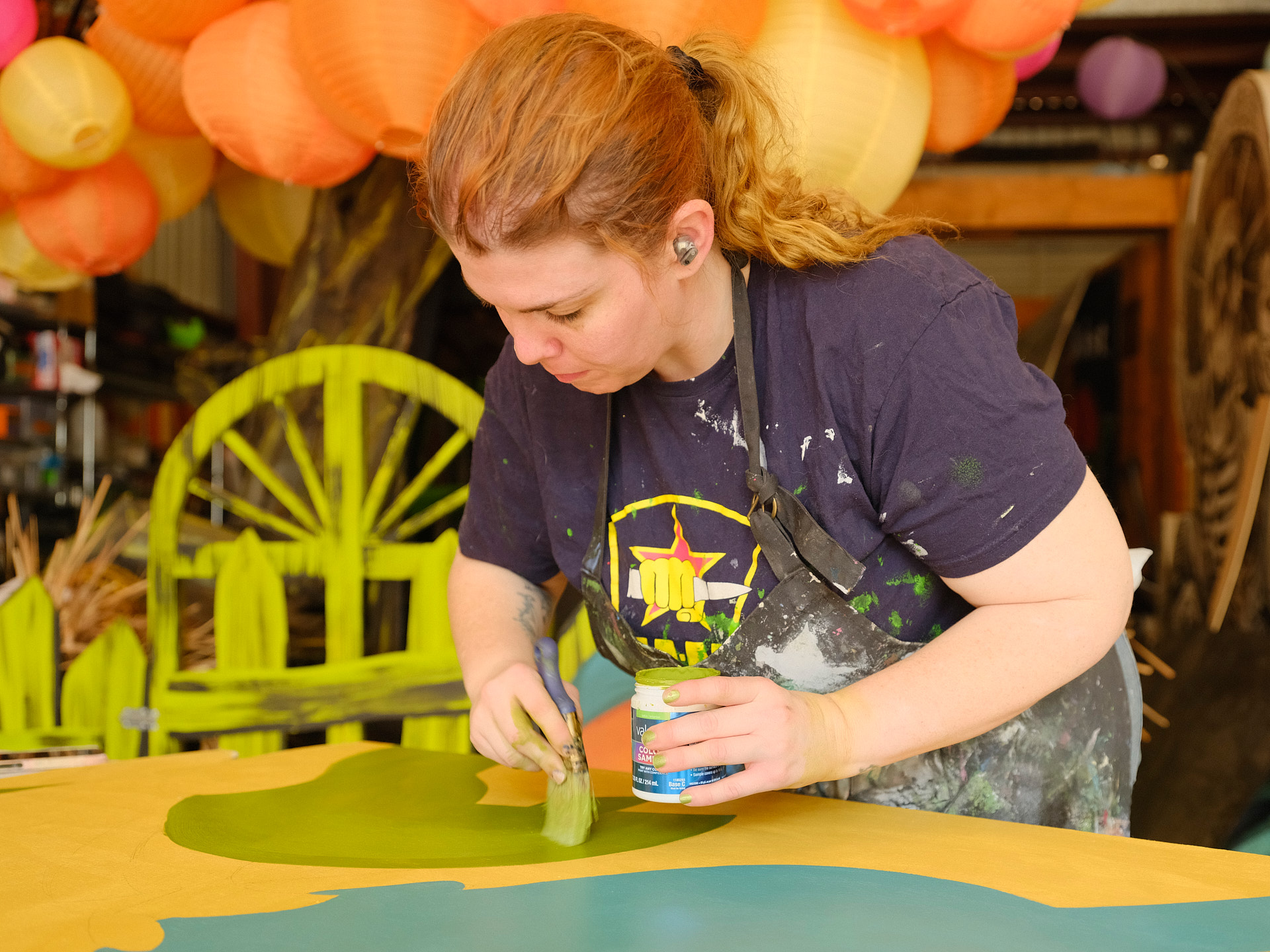 A volunteer paints details on a float.