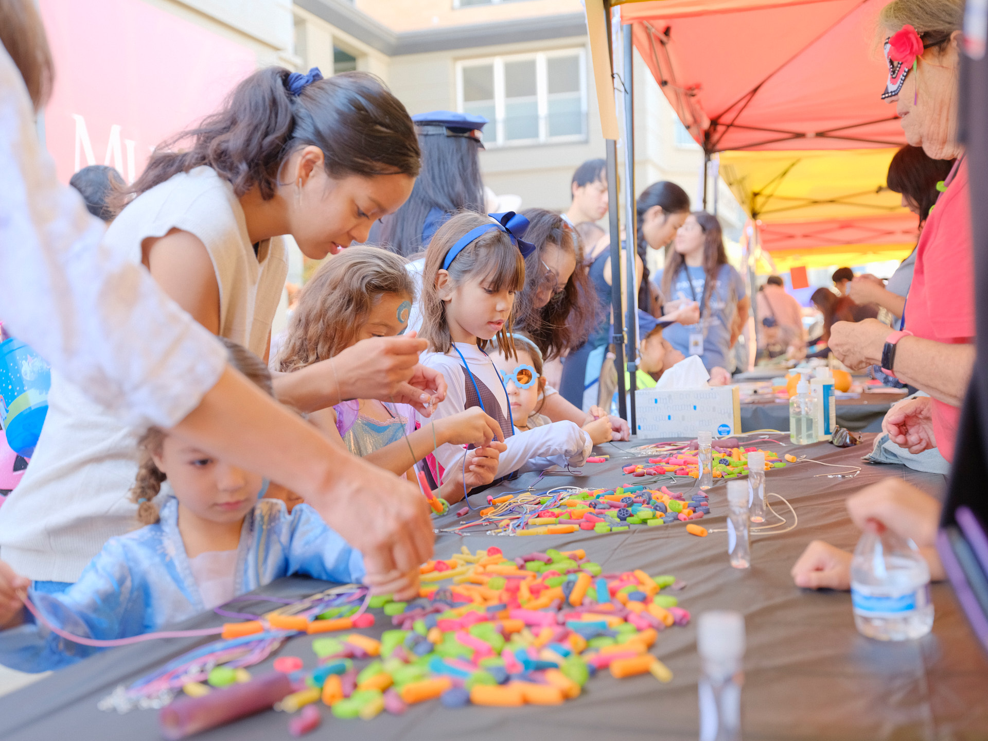 Children make crafts at a table At the Anaheim Fall Festival